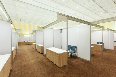Trade show interior with booth and tablesの写真素材