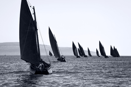 Traditional wooden boats Galway Hooker, with red sail, compete in regatta. Ireland.の写真素材