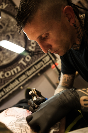GALWAY, IRELAND - SEPTEMBER 12: Tattoo Artists at work during The 3rd Annual  International Galway Tattoo Show , on September 12, 2015 in Galway, Ireland.のeditorial素材
