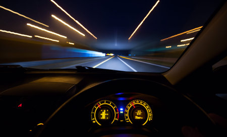 Driver view at speeding car  dashboard and motorway  at night