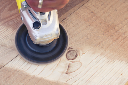 Sanding wooden sleepers  with angle grinder. Close upの写真素材