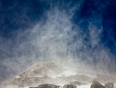 High winds close to the peak of the Jade Dragon Snow Mountain cause snow to rise into the air.の写真素材