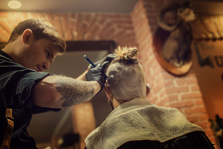 Mens hairstyling and haircutting in a barber shopの写真素材