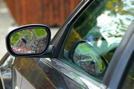 Broken left car mirror and blurry background