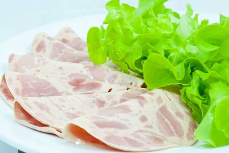 ham and vegetable on white dishの写真素材