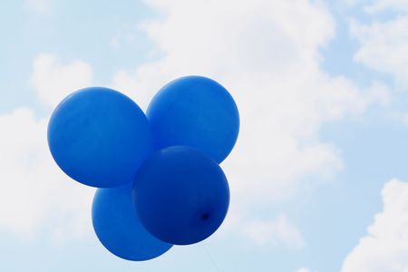 Four blue balloons in the skyの写真素材