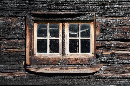 window in a burned wooden houseの写真素材