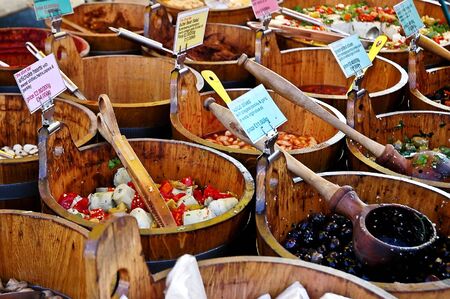 Olives for sale in wooden tubs at a market stallの写真素材