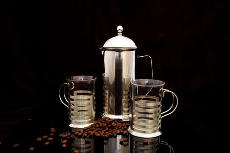 Coffee pot with cups and coffee beans isolated on blackの写真素材