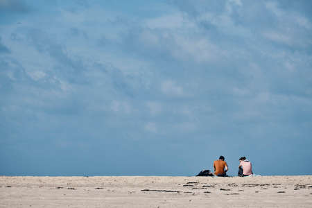 Couple sitting on the beachの写真素材