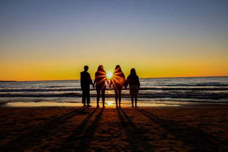 Silhouette of a family on the beach at sunset in summer, canada