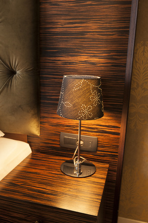 Bedside lamp on a wooden bedside tableの写真素材