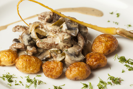 Beef in mushroom sauce served with roasted new potatoesの写真素材