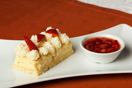 Strawberry cake with strawberry sauce served on the sideの写真素材