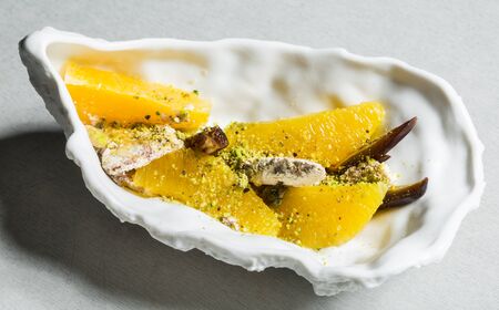 Date and orange salad with halva and pistachio yoghurtの写真素材