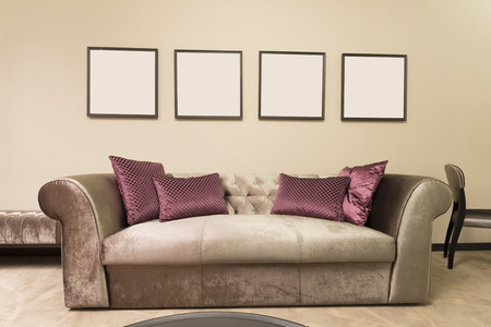 Sofa in a room with four empty picture frames