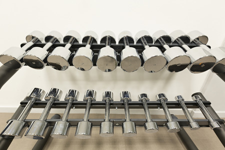 Dumbbells lined up in a fitness studioの写真素材