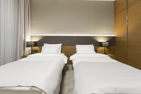 Interior of a new modern hotel bedroom in the eveningの写真素材