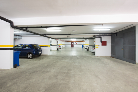 Underground parking lot, interior with a few parked cars.の写真素材