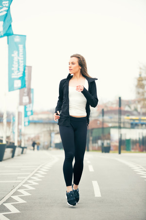 Fit fitness woman running exercises outdoorsの写真素材