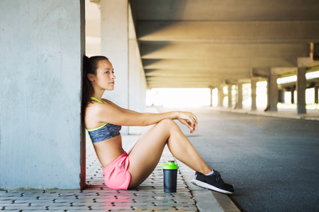 Fit fitness woman doing stretching exercises outdoorsの写真素材