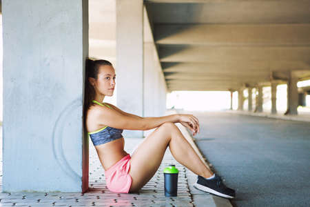 Fit fitness woman doing stretching exercises outdoorsの写真素材