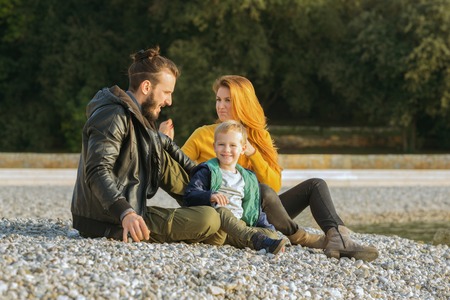 Couple with child on beach in fall
