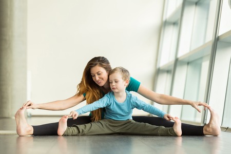 pregnant woman doing prenatal yoga with childの写真素材