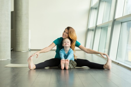 pregnant woman doing prenatal yoga with childの写真素材