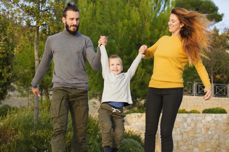 A happy family walks through the autumn parkの写真素材