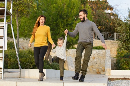 A happy family walks through the autumn parkの写真素材