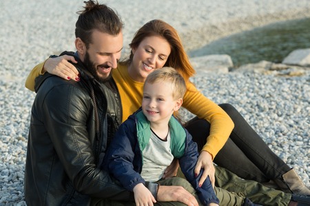 Couple with child on beach in fallの写真素材