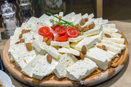 Goat cheese with almonds served on wooden boardの写真素材