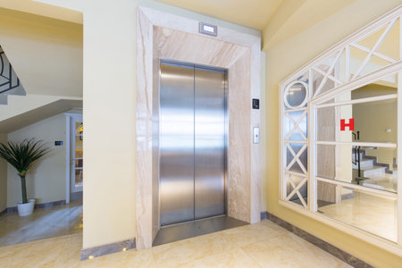 Hotel corridor with shiny metal elevatorの写真素材