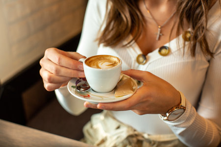 Gorgeous young woman drinking coffee alone in the restaurantの写真素材