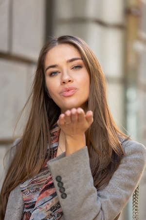 Young woman sending air kiss to cameraの写真素材