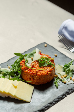 Tartare beefsteak served with cheese and arugula on black stoneの写真素材