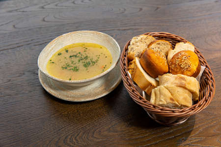 Chicken soup served with bread on a wooden tableの写真素材