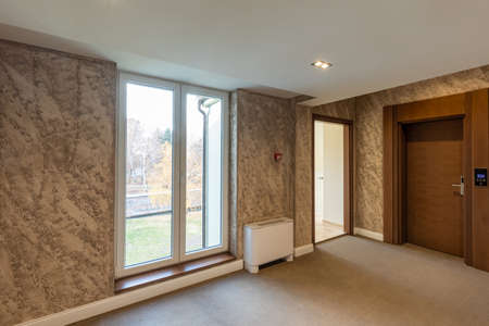Interior of a carpeted hotel corridor doorway with brown wooden doorsの写真素材