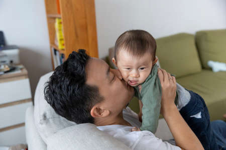 Father playing with baby boy, Japanese familyの写真素材