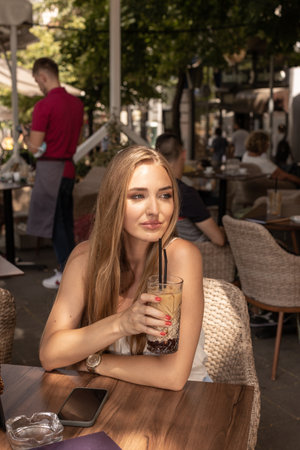 Young woman drinking coffee with strawの写真素材