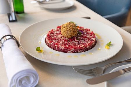 Tartare beef served on a white plate in the restaurantの写真素材