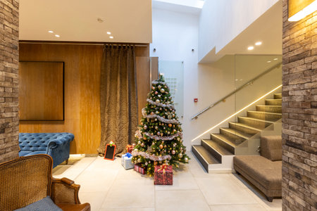 Christmas tree with wrapped presents in hotel lobbyの写真素材