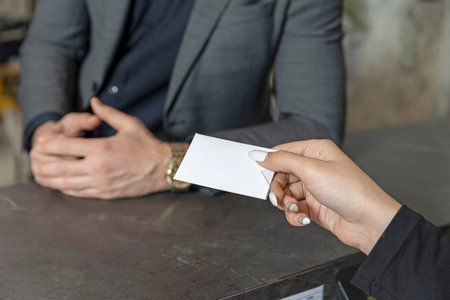 Receptionist giving card key to guest close up handsの写真素材