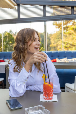 Young woman drinking cocktail alone in the restaurantの写真素材