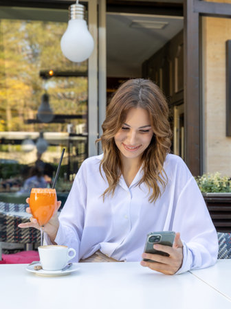 Beautiful woman texting on her smartphone in a cafe barの写真素材