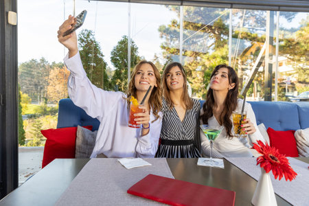 Girlfriends taking selfie in a cafe barの写真素材