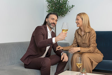 Attractive middle aged couple drinking wine in hotel room