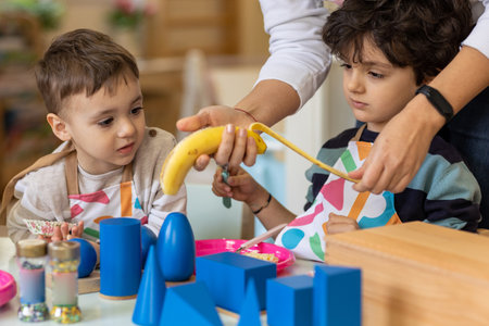 Kids prepering food in the montessori  kindergarten,  banana cokiesの写真素材
