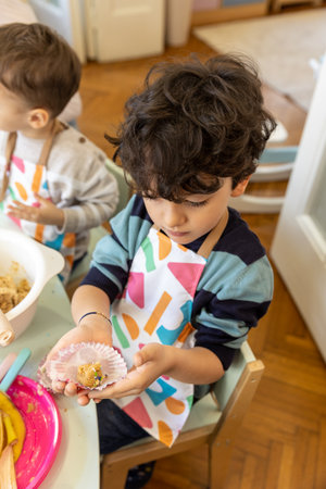 Kids showing food they made by themselves in the montessori kindergarten, banana cookiesの写真素材